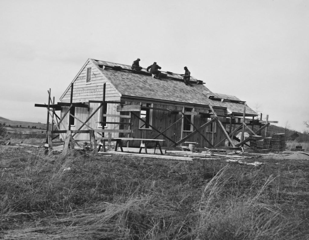 Workers constructing a house roof with scaffolding