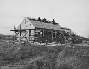 Workers constructing a house roof with scaffolding