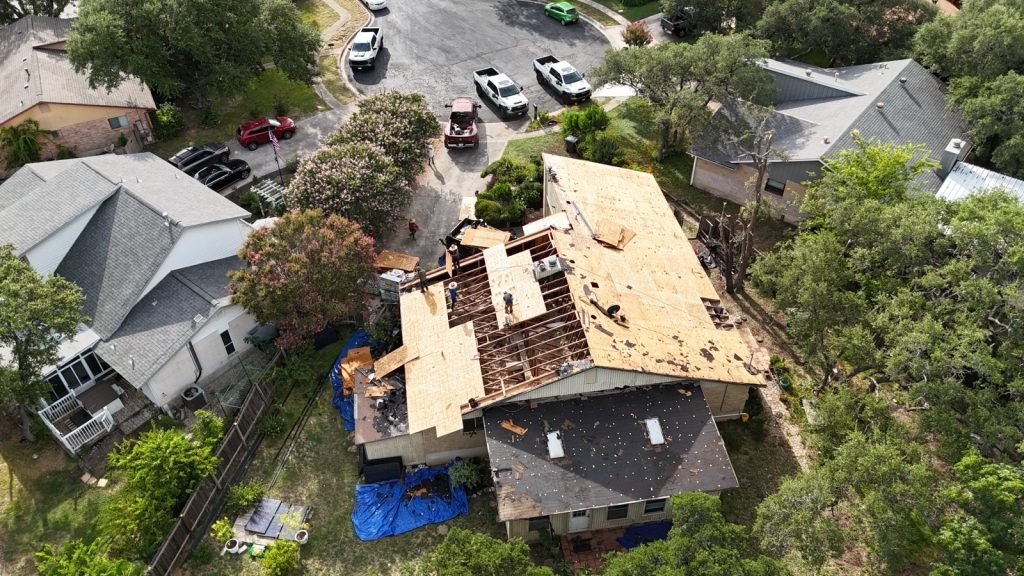 Roof tear-off in progress with property protected by tarps